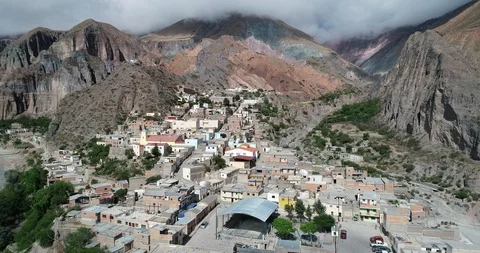 Flying over Iruya, town at steep narrow valley surrounded of woods and dry color Видео 103510710