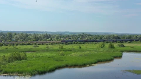 Flying over the lake in the direction of a moving passenger train Stock Footage 116643219