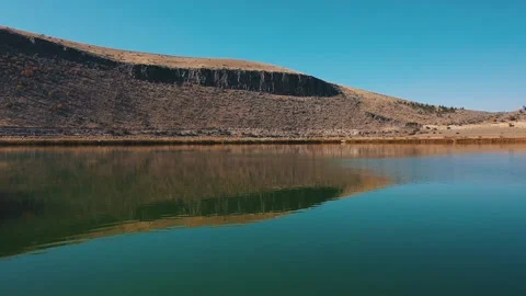 Flying over the lake in the middle of the sandy hills. Close-up Stock Footage 169223961