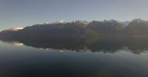 Flying Over Lake with Reflection of Snow-capped Mountains Stock Footage 77897876