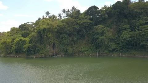 Flying over the lake to the small waterfall falling from mountain. Stock Footage 113604247