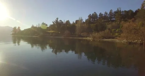 Flying Over Lake with Snow-capped Mountains and Trees Stock Footage 77898700