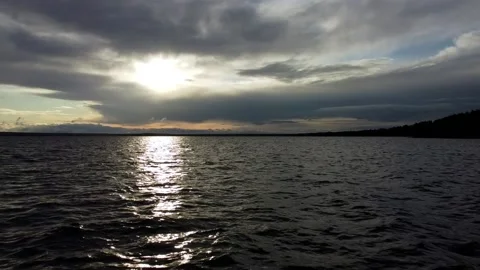 Flying over the lake towards the setting sun Stock Footage 130874997