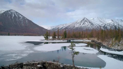 Flying over lakes with floating ice with snowcapped mountains around Stock Footage 91325387