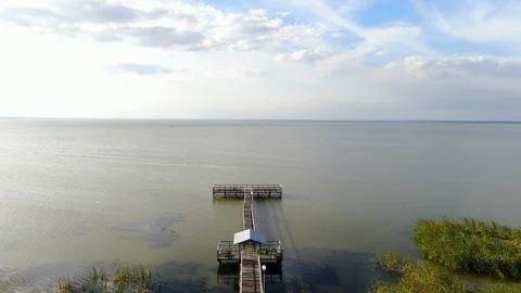Flying over a lakeside dock, landing in a park on Lake Apopka, Florida Stock Footage