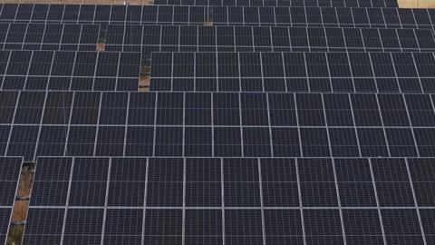 Flying over a large array of photovoltaic solar panels arranged across a solar Video stock 342779008