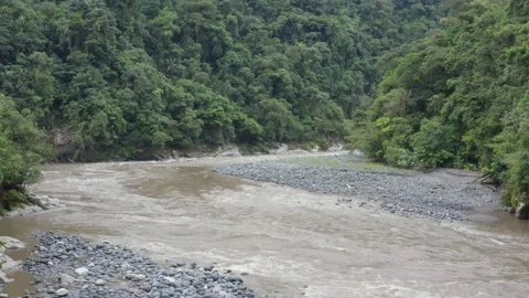 Flying over a large fast flowing river in the Andes of South America Video stock 143676364