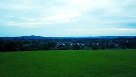 Flying up over a large open field with views of a small town Stock Footage 140800239
