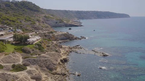 Flying over large rocky beach with turquoise water Stock Footage 101281938