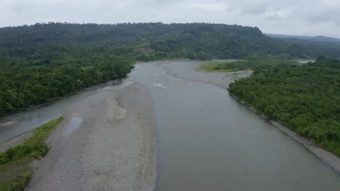Flying over a large tropical river, approaching the quick current of the water Stock Footage 169909023
