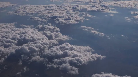 Flying over the layer of clouds and looking on landscape through the clouds. Stock Footage 112146396