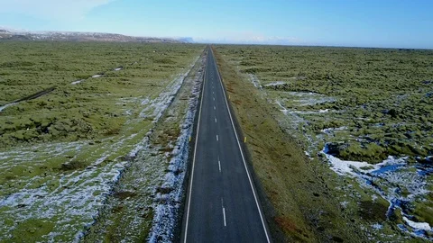 Flying over long road and green moss field on volcanic rock in Iceland Stock-Footage 90540388