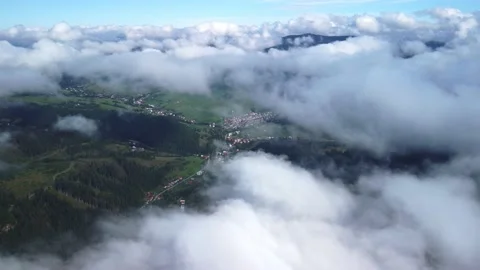 Flying over low clouds in the morning. Wooded hilly country landscape. Stock Footage 221788786