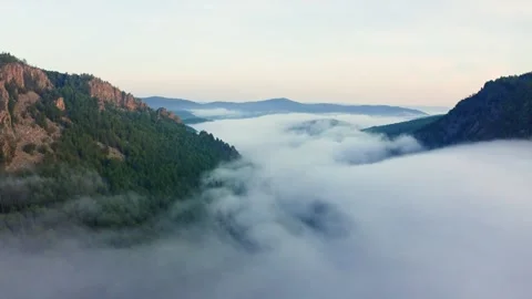 Flying over low clouds in a mountain valley in morning Vídeo Stock 263776184