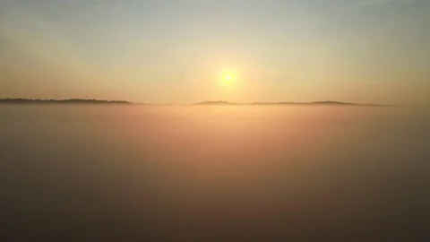 Flying over low mist while the sun rises Stock Footage 164597883