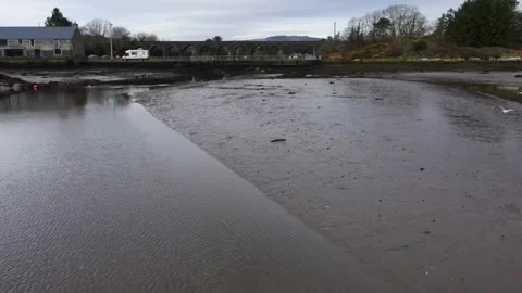 Flying Over the Low Tide River to the old railway bridge.Ireland. Cork. Aerial Stock Footage 232298898