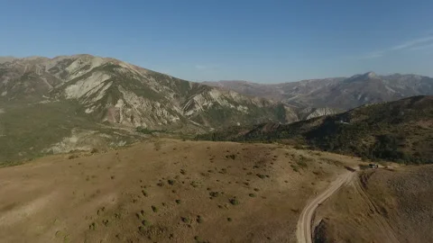 Flying Over Lush Fields Towards Mountains 動画素材 317773445