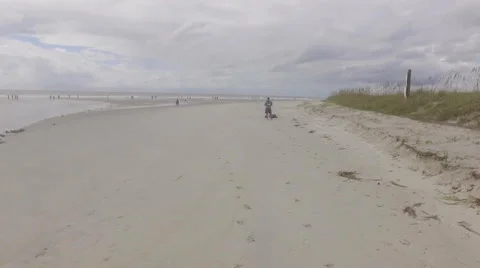 Flying over man on beach and climbing to high view of beach Stock Footage 68816034