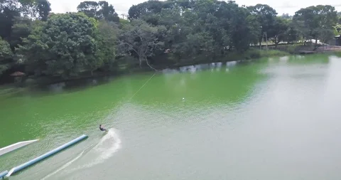 Flying over Man Wakeboarding Cable. Smooth Slide on Water. Aerial View Vídeo Stock 88976602