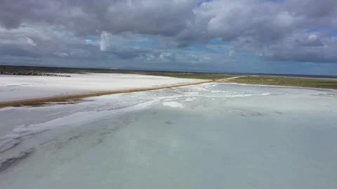 Flying over mirror surface of saline pond 動画素材 256932579
