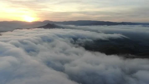 Flying over the mist lying in the valley visible only the tops of the mountains Stock Footage 132168467