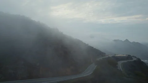 Flying over misty winding road through mountain pass Stock Footage 168215596