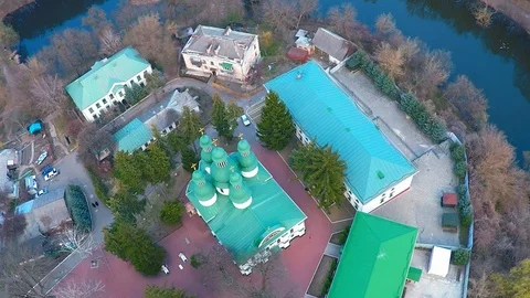Flying over the monastery near the river in the forest Stock Footage 106097236