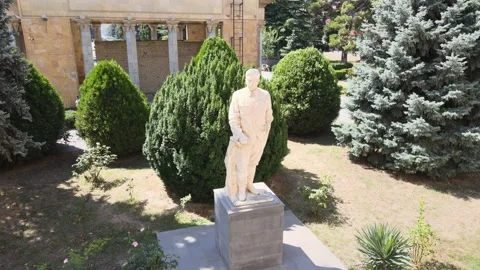 Flying over Monument of Joseph Stalin in front of the Joseph Stalin Museum 스톡 동영상 141900496