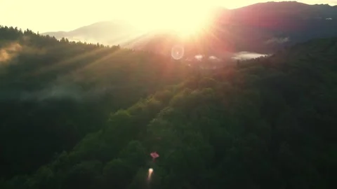 Flying over mountain forest with the sunset in the background Stock-Footage 247004089