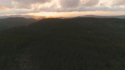 Flying up over mountain forest, view of clouds and amazing golden hour sunset Video stock 108106547