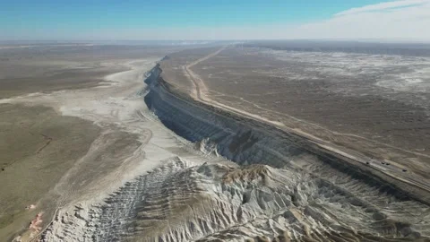 Flying over a mountain range along a road in a mountain desert Stock Footage 237693567