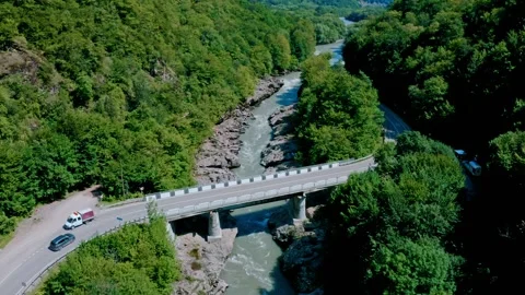 Flying over a mountain river with a car bridge Video stock 202247162