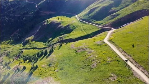Flying over mountain road with jeep  스톡 동영상 87621699