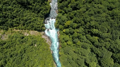 Flying over a mountain stream river, surrounded by green forest. Turquoise Video stock 112186797