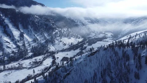 Flying over mountain valley with hanging fog above Stock Footage 310570577