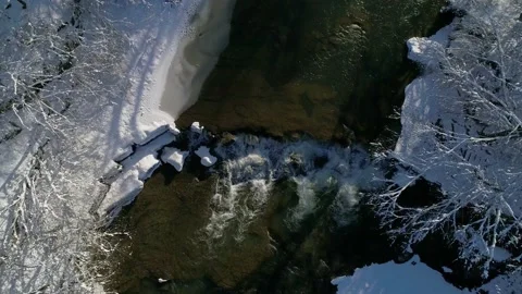 Flying up over a mountain wild clear river on a winter sunny day. Video stock 228993130