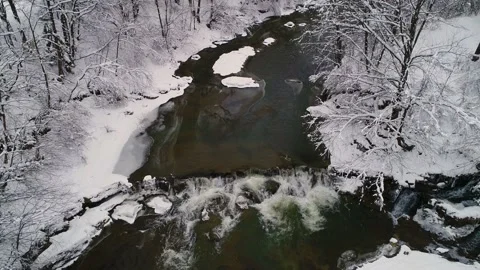 Flying up over a mountain wild clear river on a winter cloudy day. Video stock 229172247