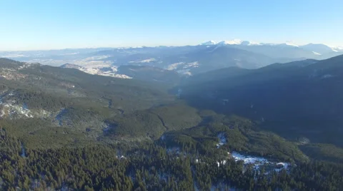 Flying over the mountains and the forest in the winter in a sunny day 02 Video stock 58881247
