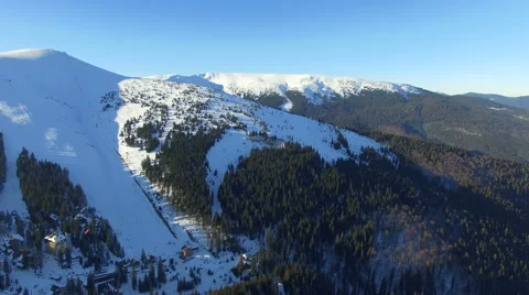Flying over the mountains and the forest in the winter in a sunny day 01 Stock Footage 58881367