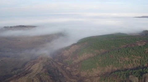 Flying over the mountains covered with trees and clouds Aerial Stock Footage 58254019