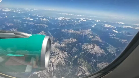 Flying over mountains with engine in sight - view from passenger airplane window Video stock 220875201