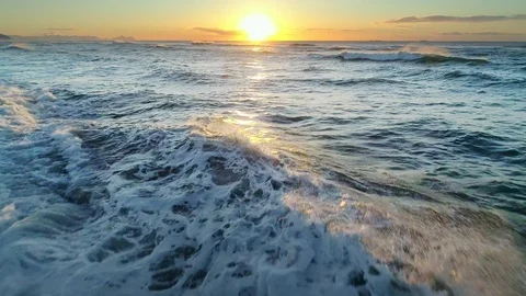 Flying over the Ocean during golden hour. Giant waves foaming and splashing in Stock Footage 110810995
