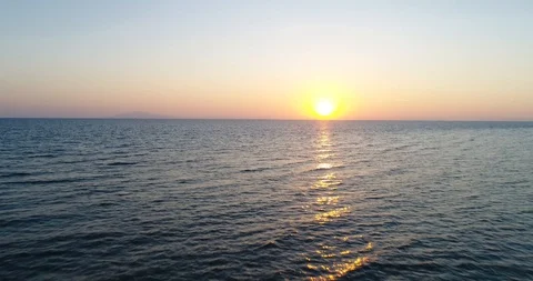 Flying over the ocean towards the setting sun Stock Footage 98931471
