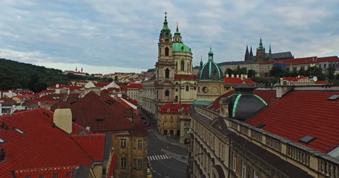 Flying over the old rooftops of Prague from the Charles Bridge, close to Church Stock Footage 61077647