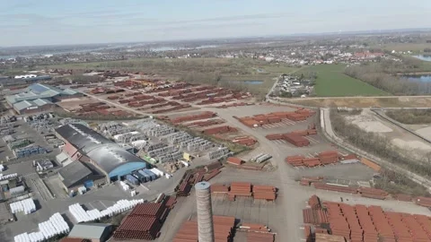 Flying over old smoke stack overlooking large industrial junk yard 動画素材 150817811