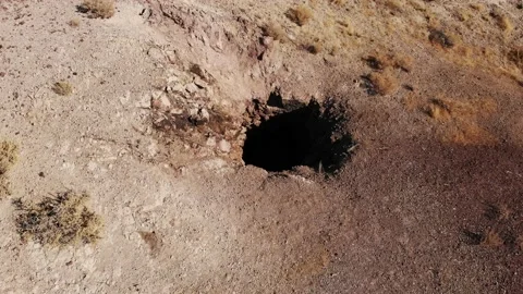 Flying Over an Open Abandoned Mine Shaft in the Desert Stock-Footage 140562613
