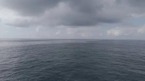 Flying over the open ocean, a drone captures slow-motion waves. Cloudy skie.. Stock Footage 280392695