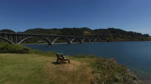Flying over a park bench towards a large bridge Stock Footage 53301829