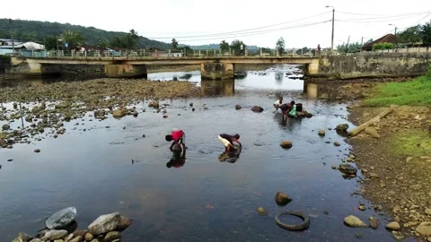 Flying over parrot river with children looking for fish under the rocks Stock Footage 199262986