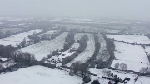 Flying over a patchwork of snow covered fields in winter 스톡 동영상 225459387